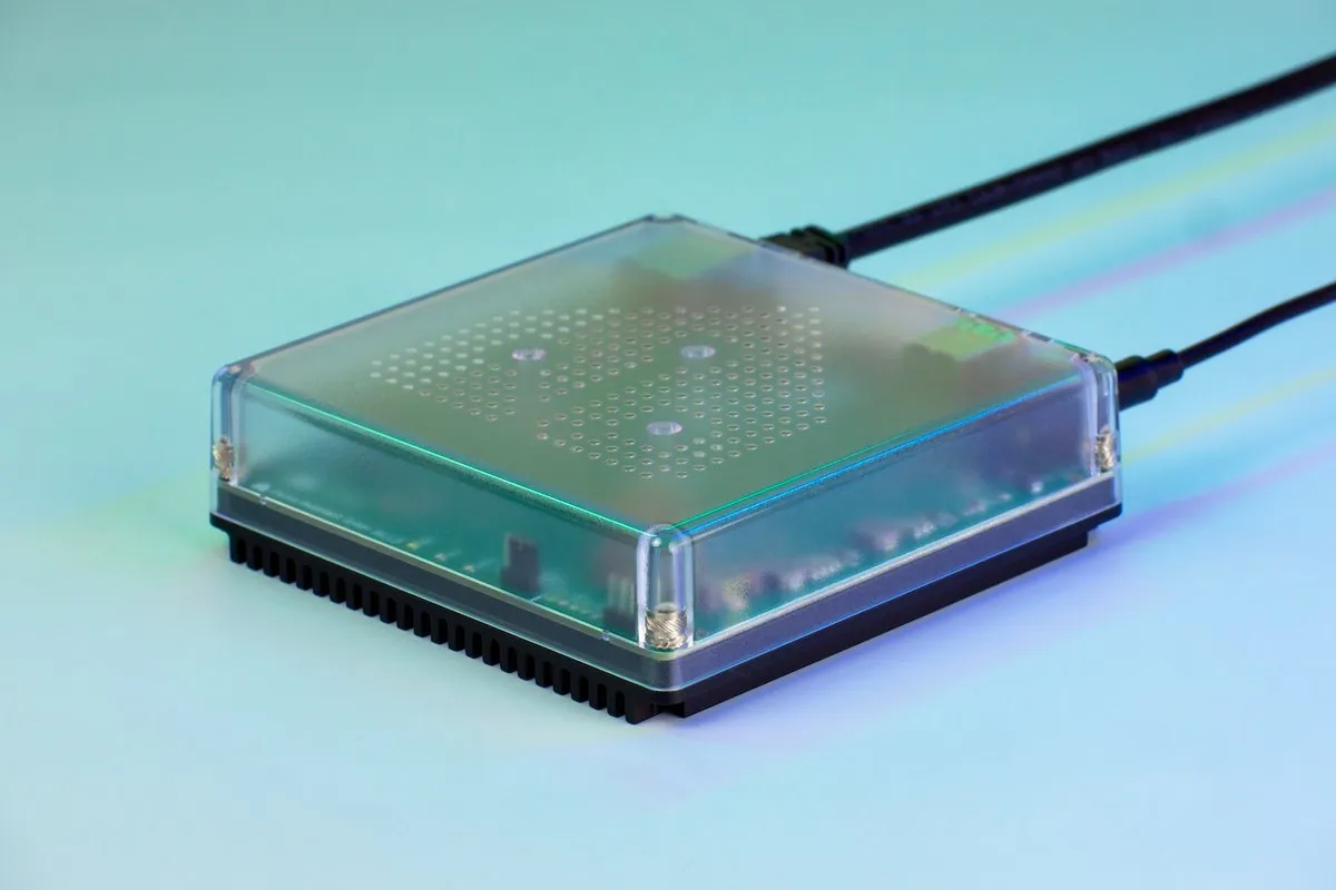 A small square hub with a clear top and a cable plugged into the back.